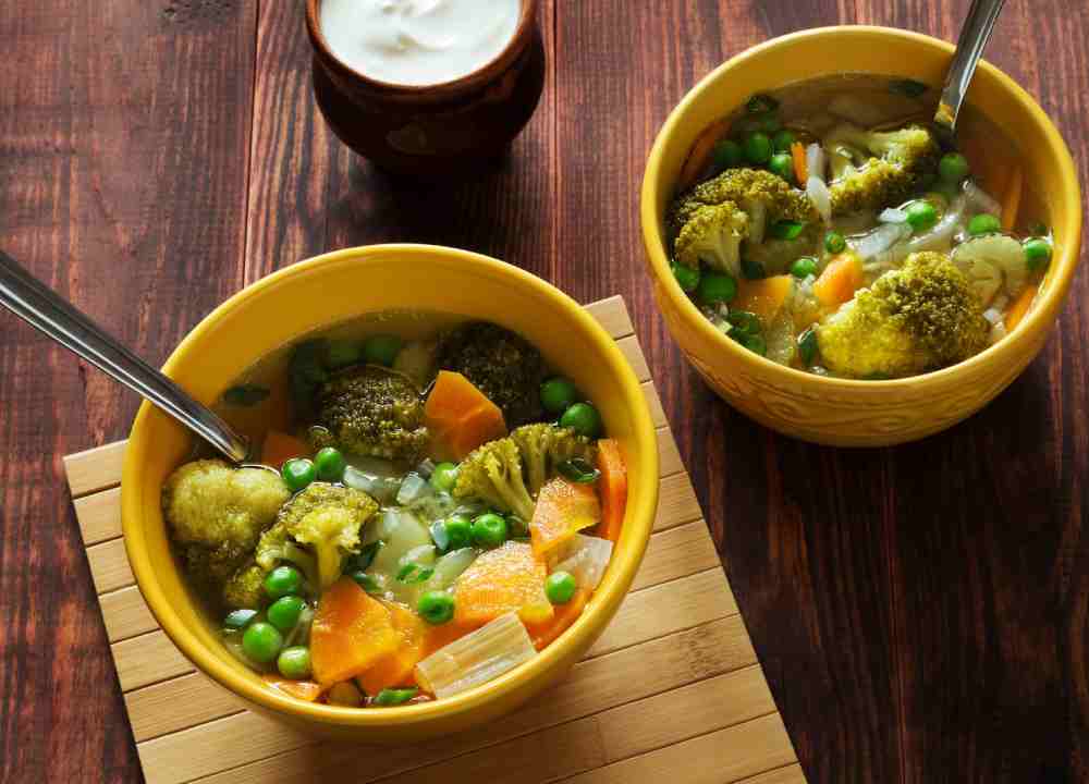 A bowl of boiled carrots and broccoli.