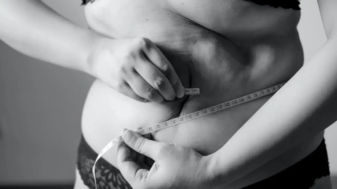 A woman measuring her belly