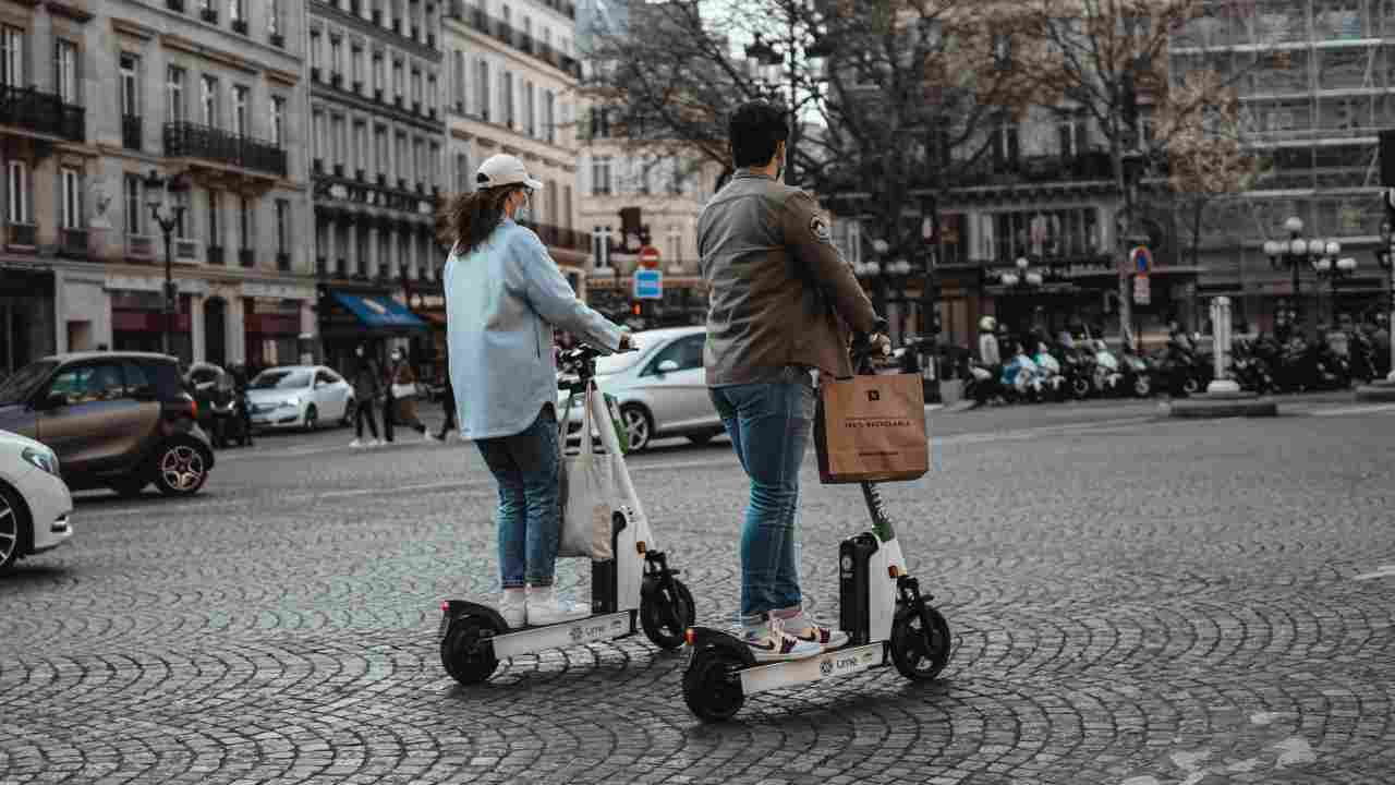 A boy and a girl travelling on a e-scooter