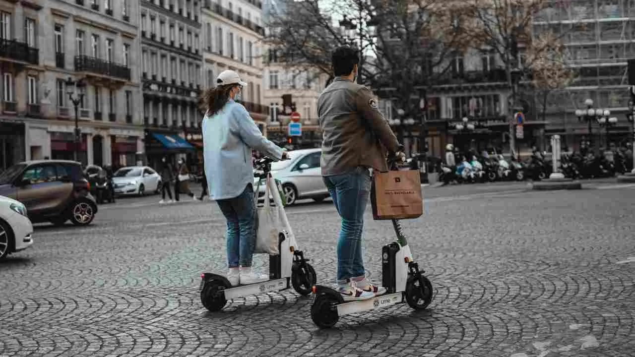 A boy and a girl travelling on a e-scooter